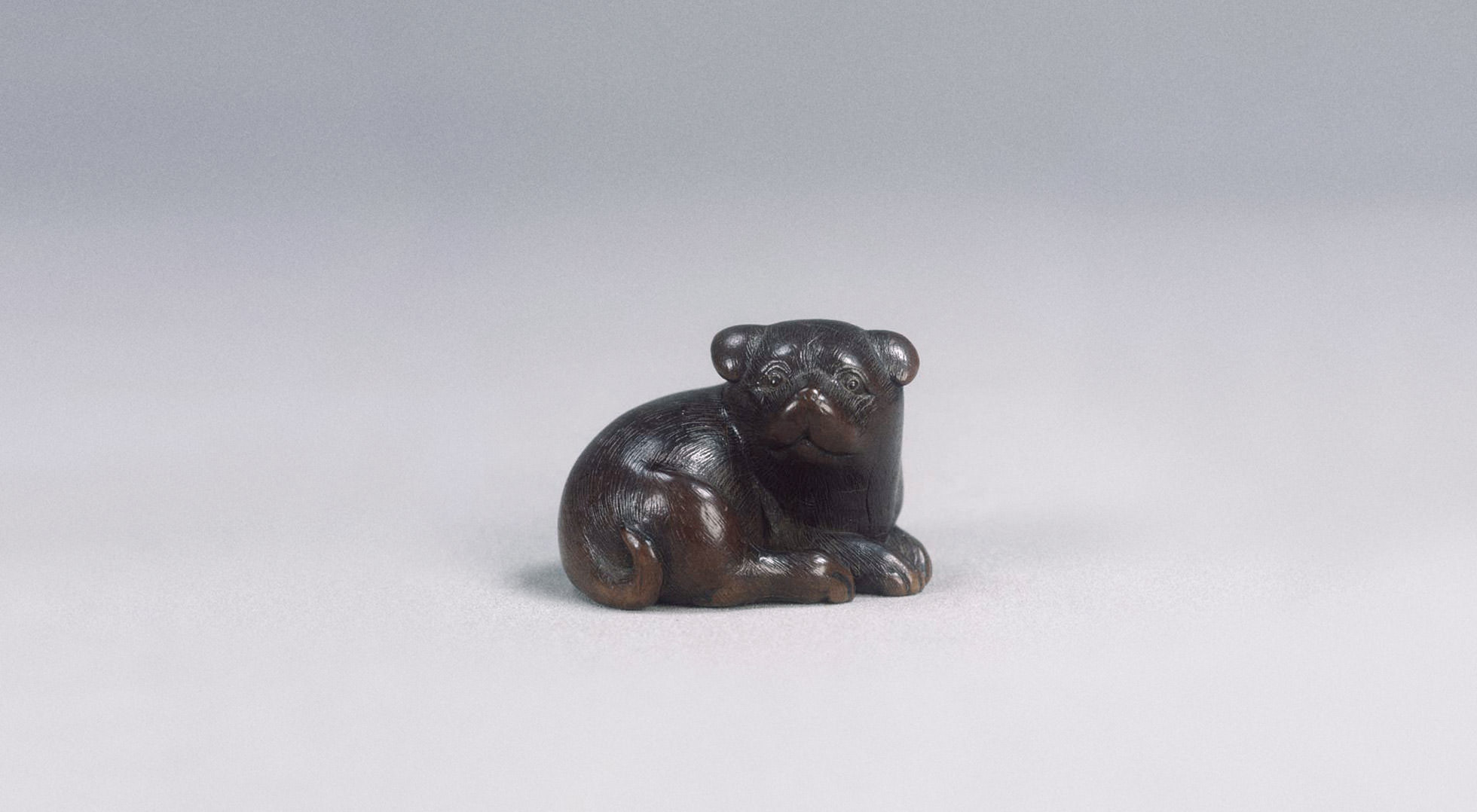 Netsuke (broche) de cachorro tallado en madera